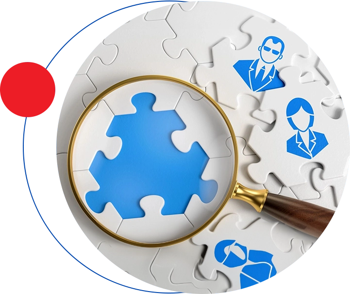 A magnifying glass is on top of puzzle pieces.